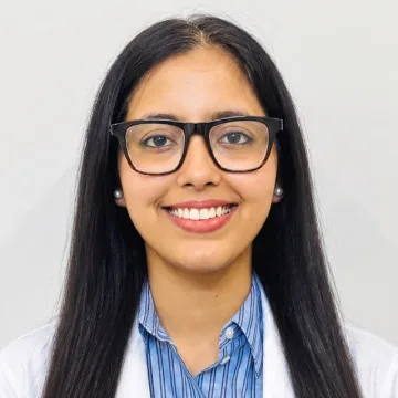 Dr. Divya Yadav in a white coat